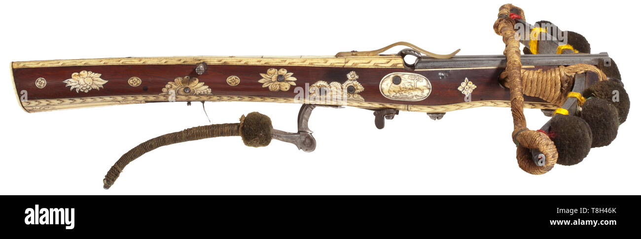 A German boy's crossbow, end of the 17th century Bright steel prod with manufacturer's mark (quartered circle with five ray points, cf. Stöckel no. 6448 - 6453), tassels made from green pompoms, original bowstring, the bounding loosened. The tiller veneered with walnut, with finest, lavish, engraved inlaid work made from bone, the bottom completely made from engraved bone, windlass toggle, multi-axle flap lock with safety and trigger. Traces of use and age, the textile parts slightly damaged, restored. Length 55 cm. During the 19th century the pr, Additional-Rights-Clearance-Info-Not-Available Stock Photo