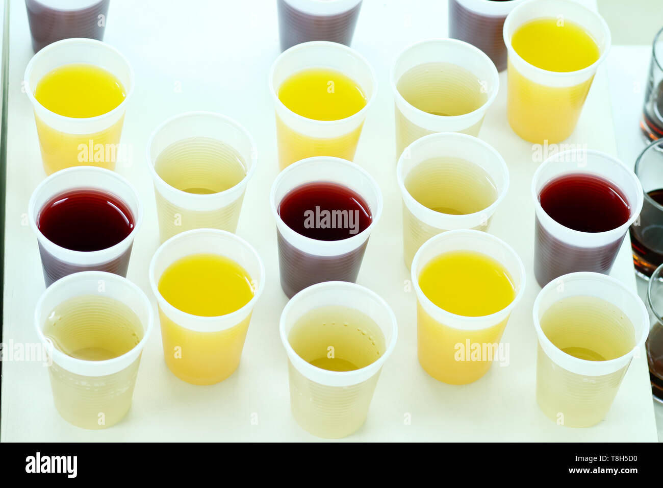 Many Plastic Cups With Various Juice On White Table Served As A
