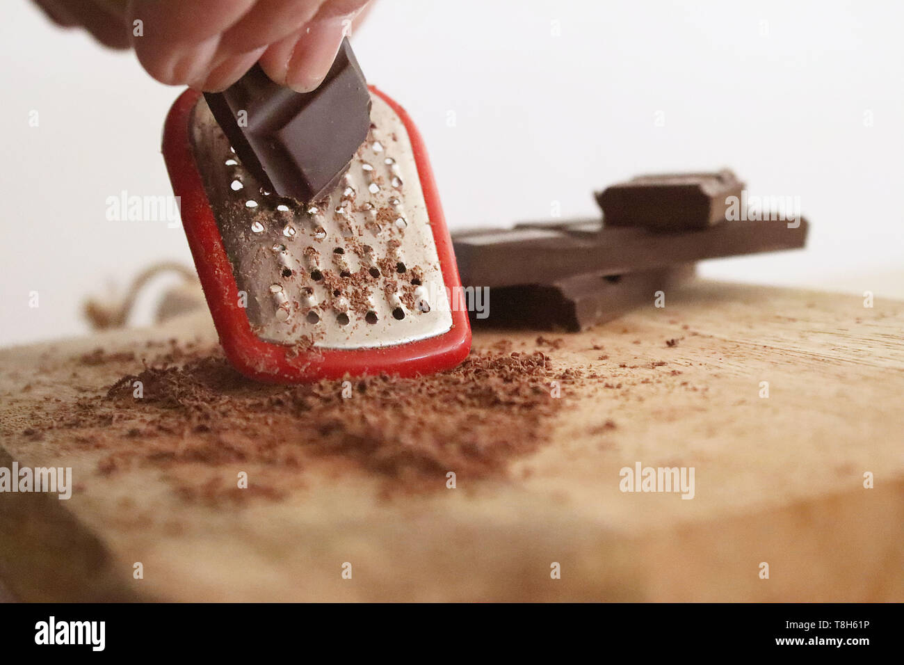 Woman grating a bar of chocolate Stock Photo
