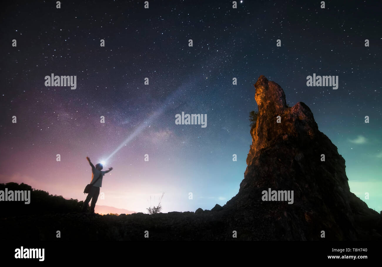 Man stand between rock mount and milky way Stock Photo