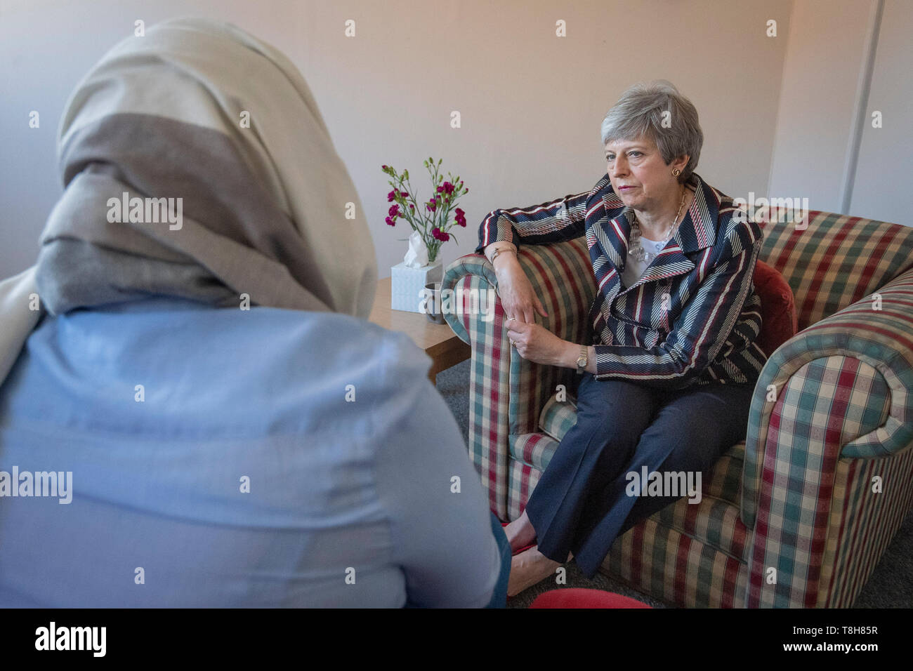 Prime Minister Theresa May talks with a survivor of domestic violence at Advance Charity offices in West London where she discussed support for victims of domestic violence. Stock Photo