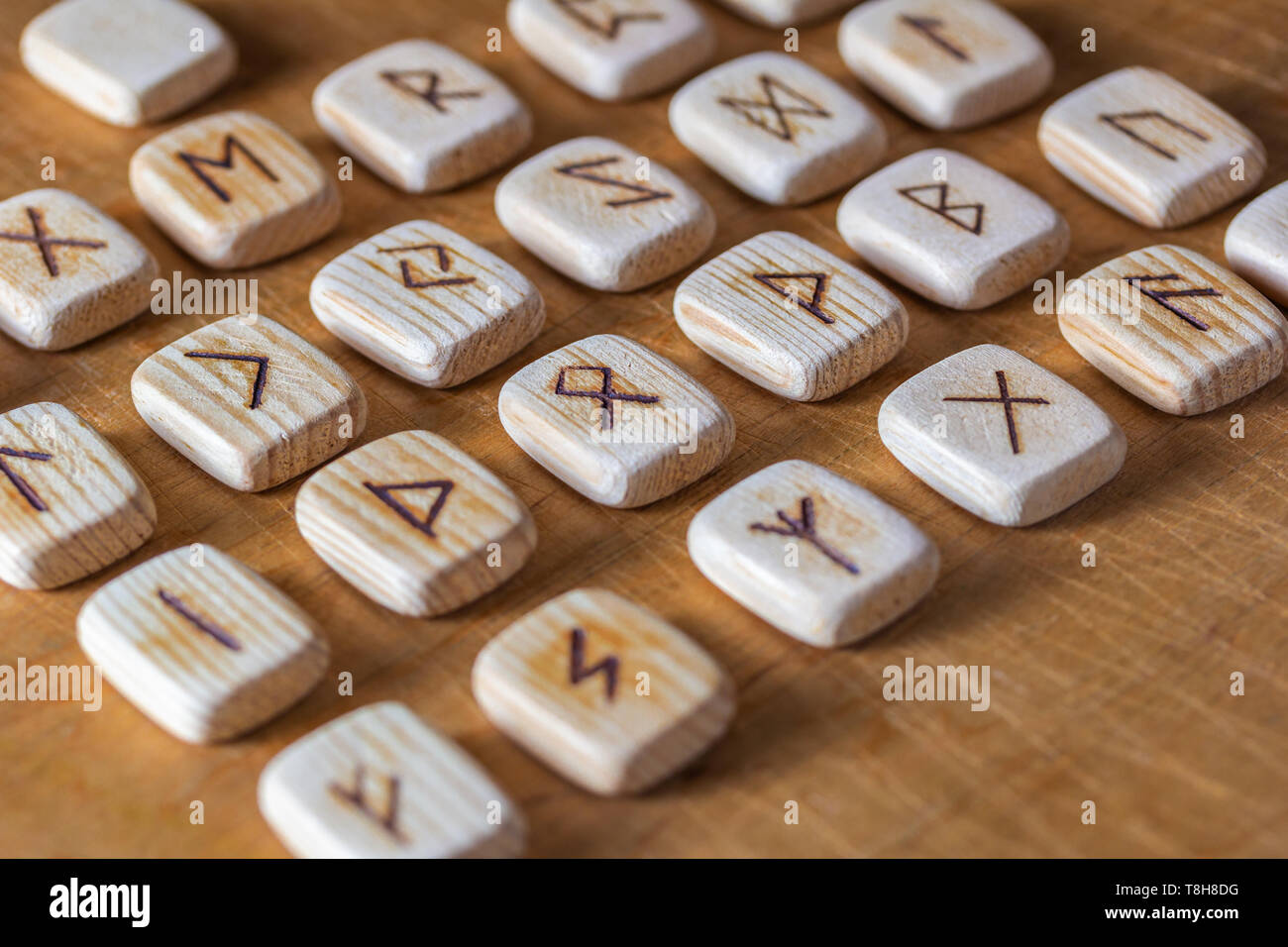 Anglosaxon wooden handmade runes on the vintage table On each rune
