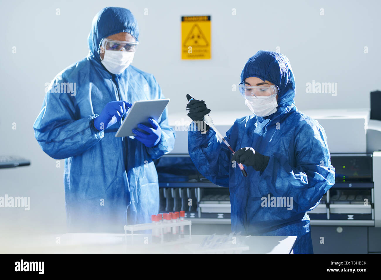 Multiethnic clinical scientists working with blood samples Stock Photo