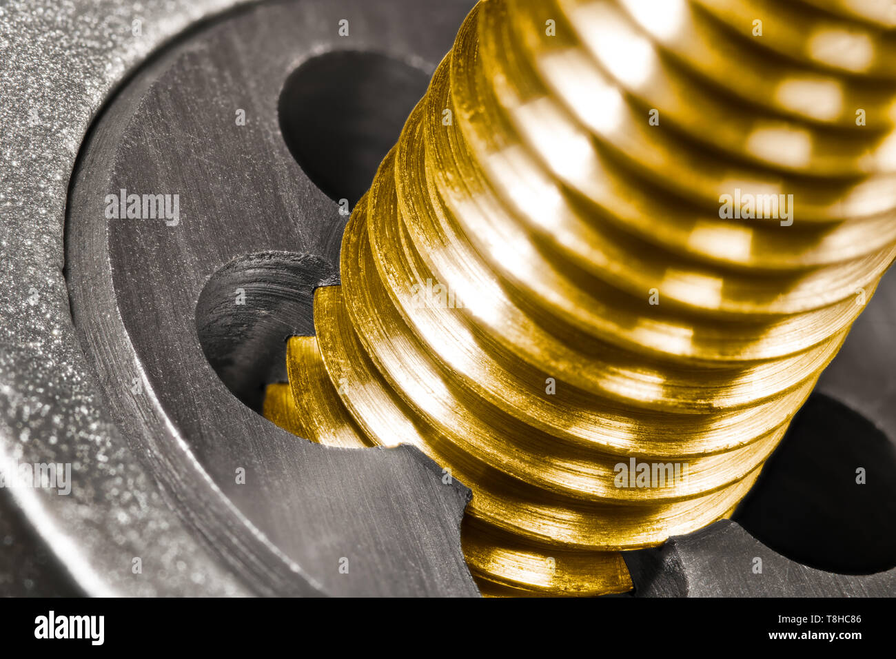 Steel threading die. Bronze bolt shaft in detail. Closeup of work with