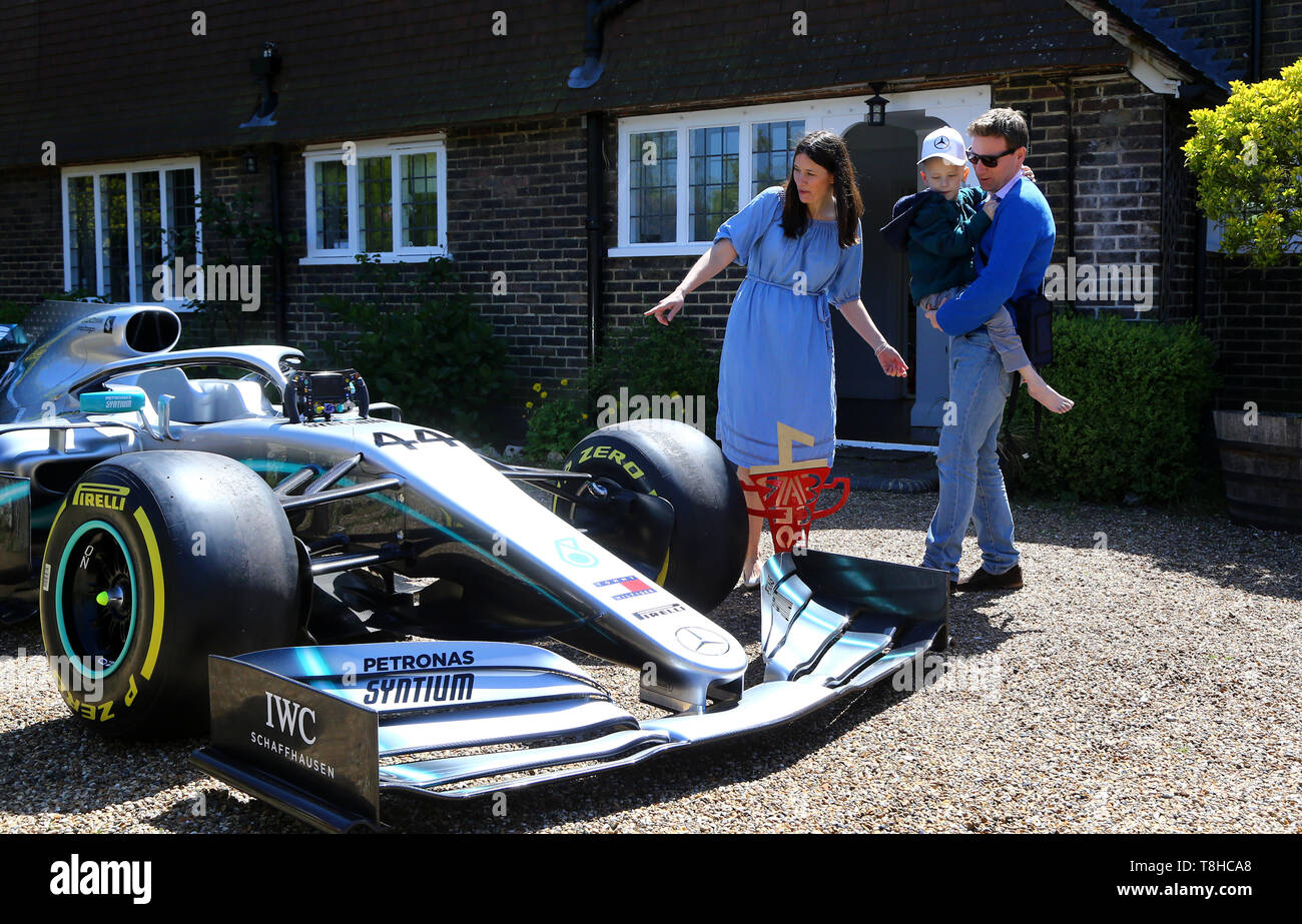 Five-year-old Harry Shaw, who has been diagnosed with a rare form of bone cancer, is carried by his father James with mother Charlotte to view a replica of Lewis Hamilton's Formula 1 car outside their home in Redhill, Surrey. Stock Photo