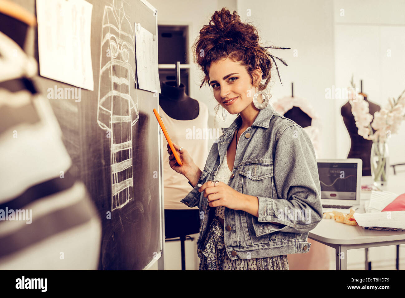 Dress designer smiling at the camera at work Stock Photo - Alamy