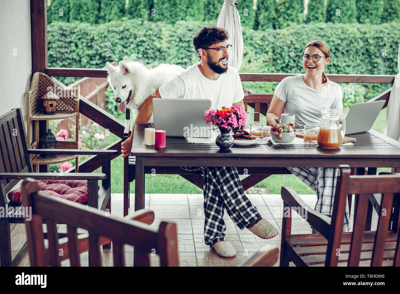 Happy freelancers sharing a laugh during breakfast in the garden Stock Photo