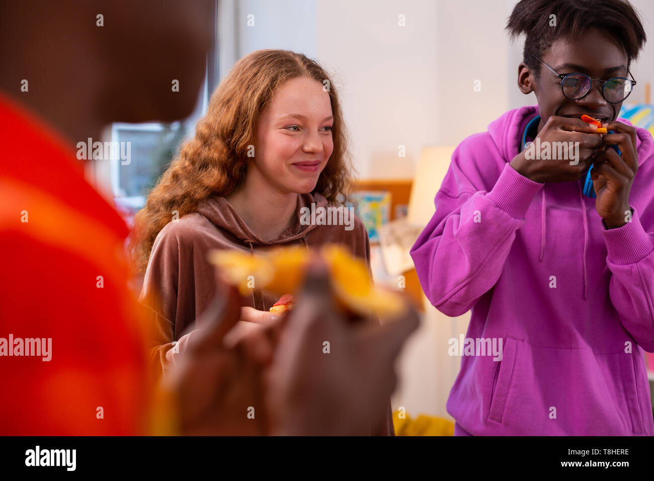 Girl laughing while having little pizza party with best friends Stock Photo