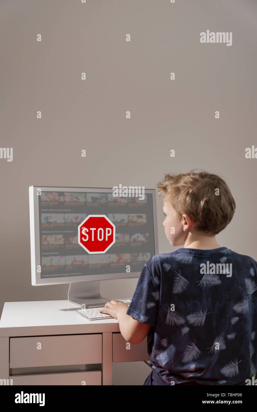 Boy, 8 years, is being stopped to view a pornograhic website in the Internet. Stock Photo