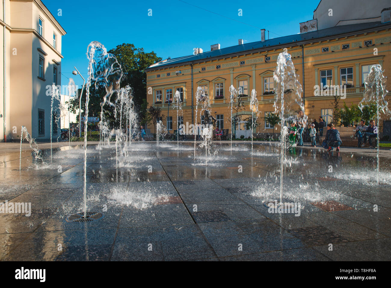 kids playing at city square near fountain. summer time Stock Photo