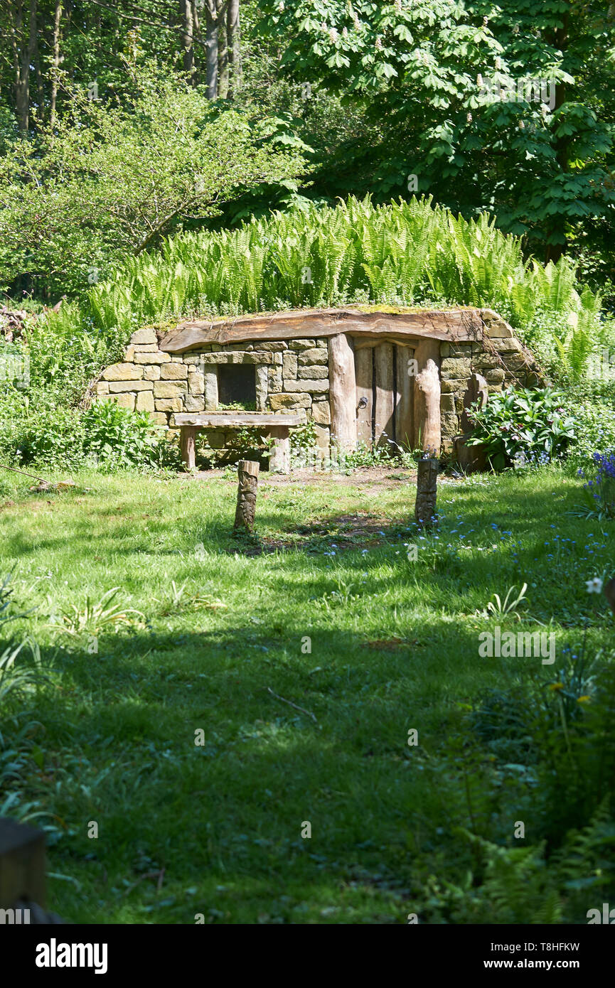 Hobbits House with springtime ferns and bluebells (Hyacinthoides non-scripta ) growing around it. East Riding of Yorkshire, UK, GB. Stock Photo