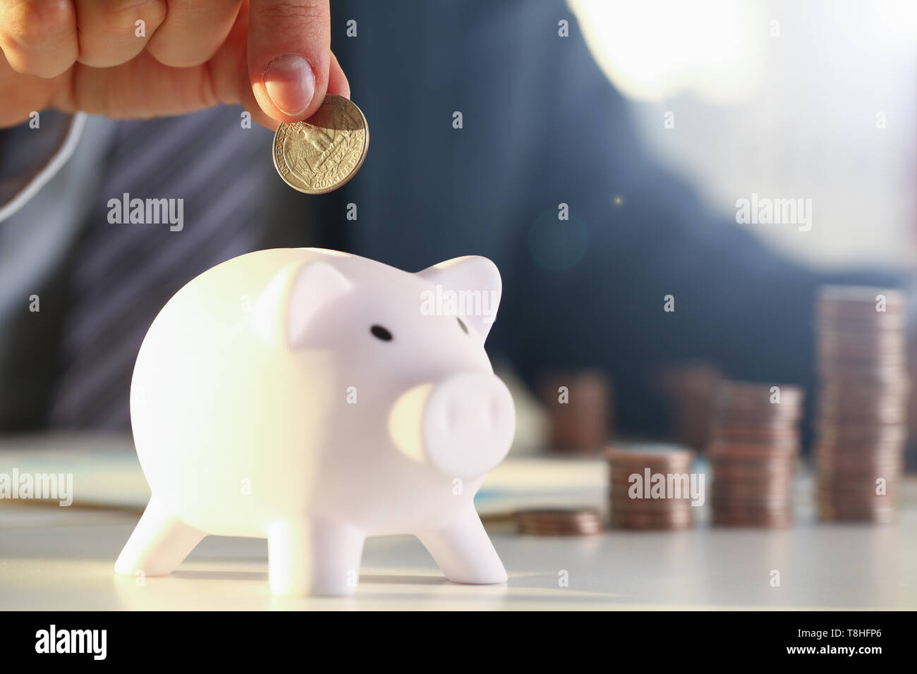 Hand businessman putting pin money into pig Stock Photo Alamy