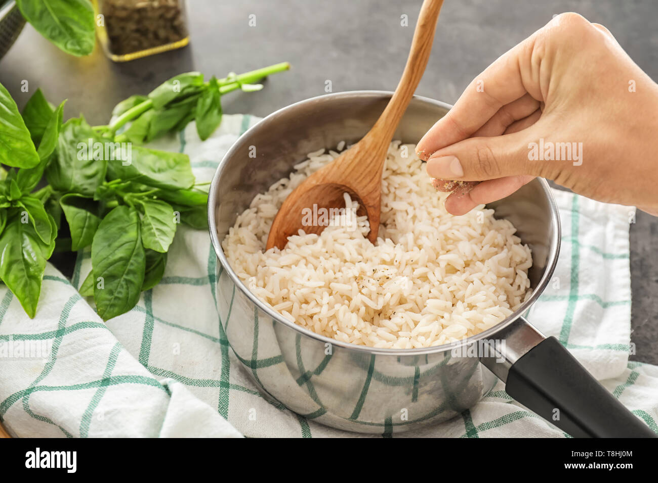 Woman adding spices to tasty rice in saucepan Stock Photo Alamy
