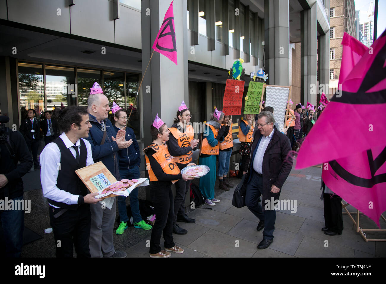 Extinction Rebellion activists target the International Maritime Organisation Climate Conference and delegates, May 13th 2019, Central London, United Kingdom. The activists handed out pink xr biscuits, a string ensemble played and a couple were busy re-arranging the deck chairs, all a play on the sinking Titanic. Stock Photo