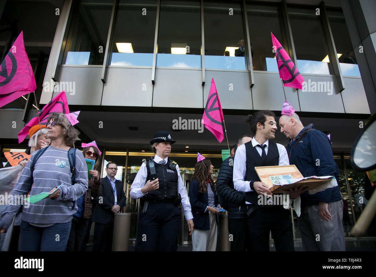 Extinction Rebellion activists target the International Maritime Organisation Climate Conference and delegates, May 13th 2019, Central London, United Kingdom. The activists handed out pink xr biscuits, a string ensemble played and a couple were busy re-arranging the deck chairs, all a play on the sinking Titanic. Stock Photo