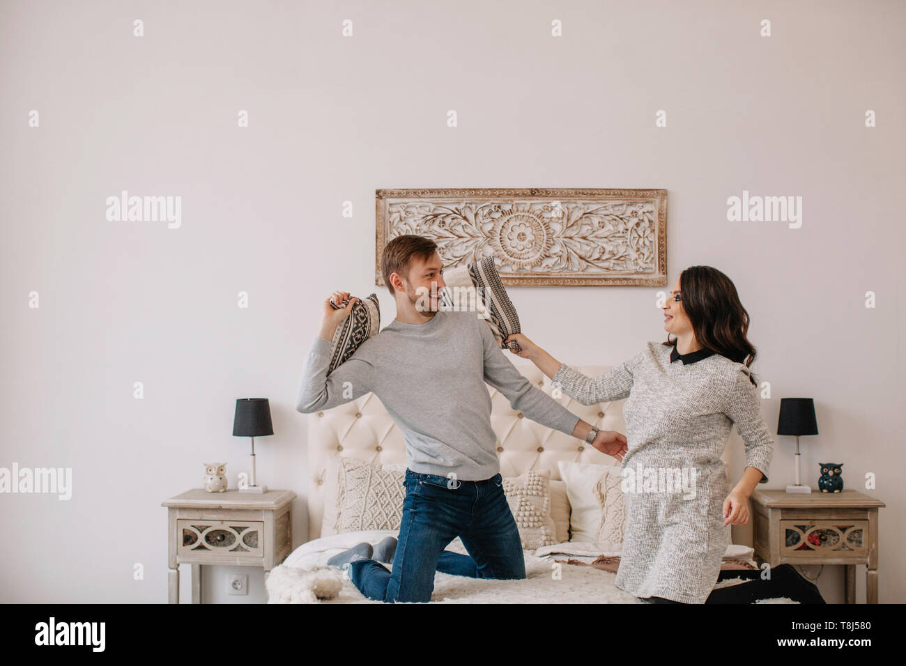 Couple having a pillow fight in the bedroom Stock Photo