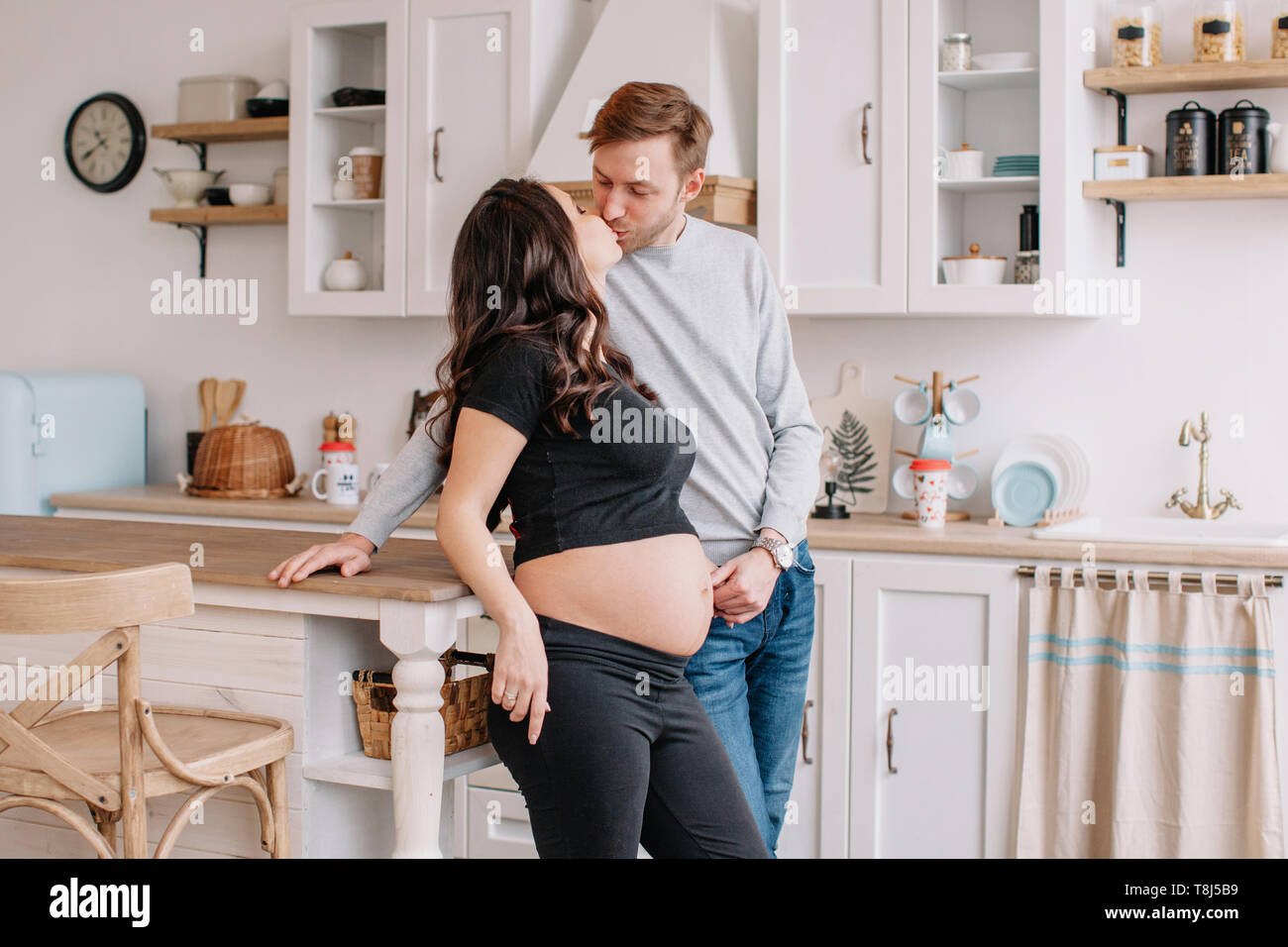 Portrait of a smiling couple kissing in the kitchen Stock Photo