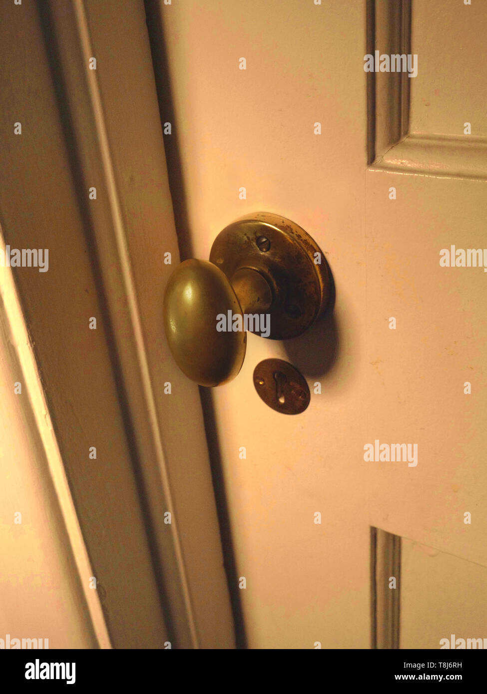 Close up of a brass door handle on a closed old wooden door. Stock Photo
