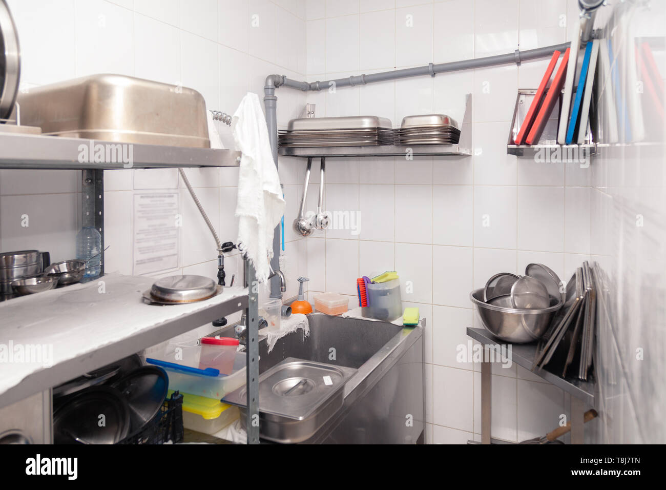 Utensils on metal rack in commercial kitchen Stock Photo - Alamy