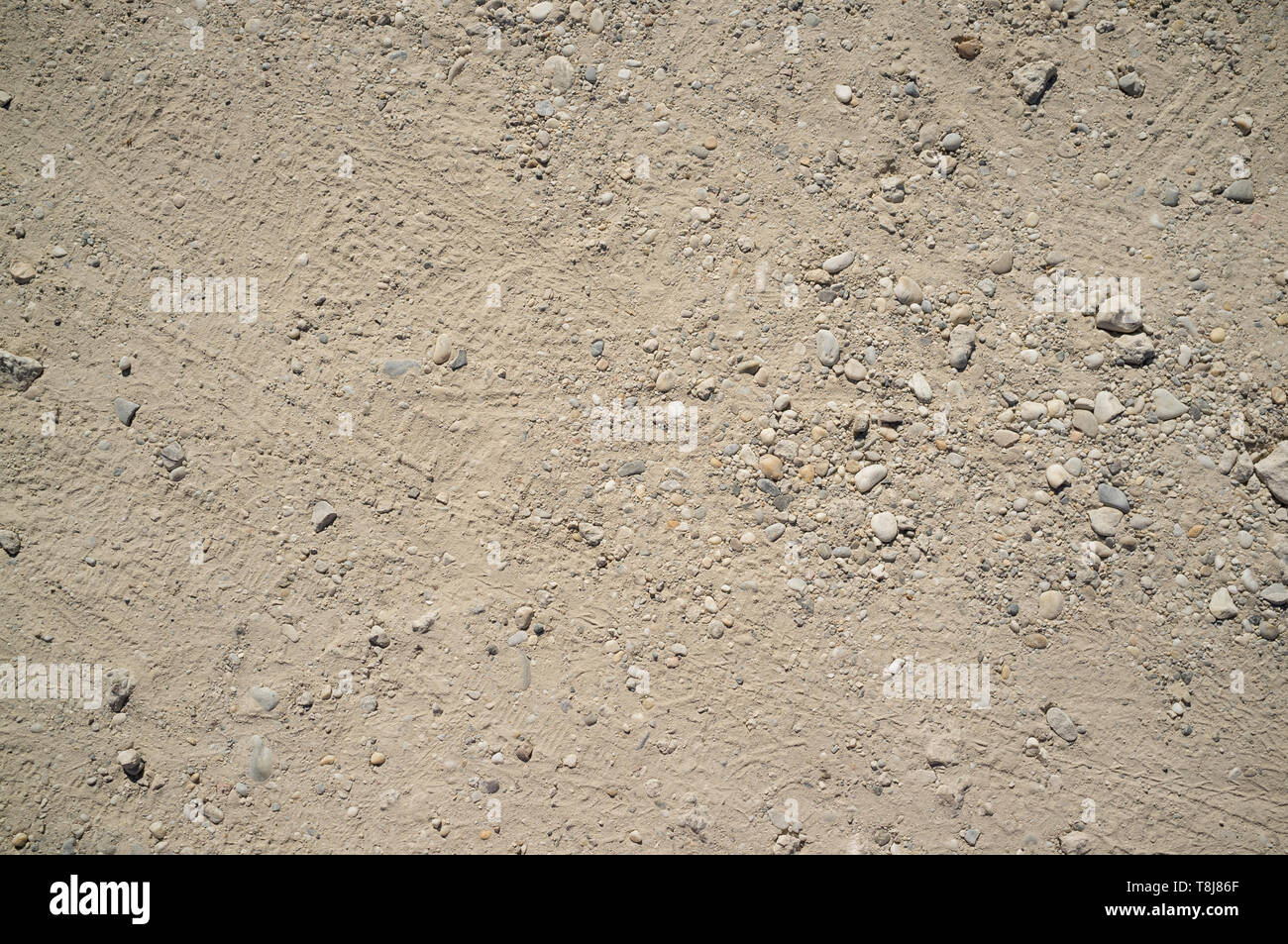 Dusty Road with Small Rocks, Dirt, Footprints, Car and Bicycle Traces Texture Stock Photo