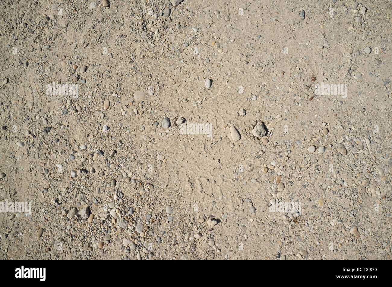 Dusty Road with Small Rocks, Dirt, Footprints, Car and Bicycle Traces Stock Photo