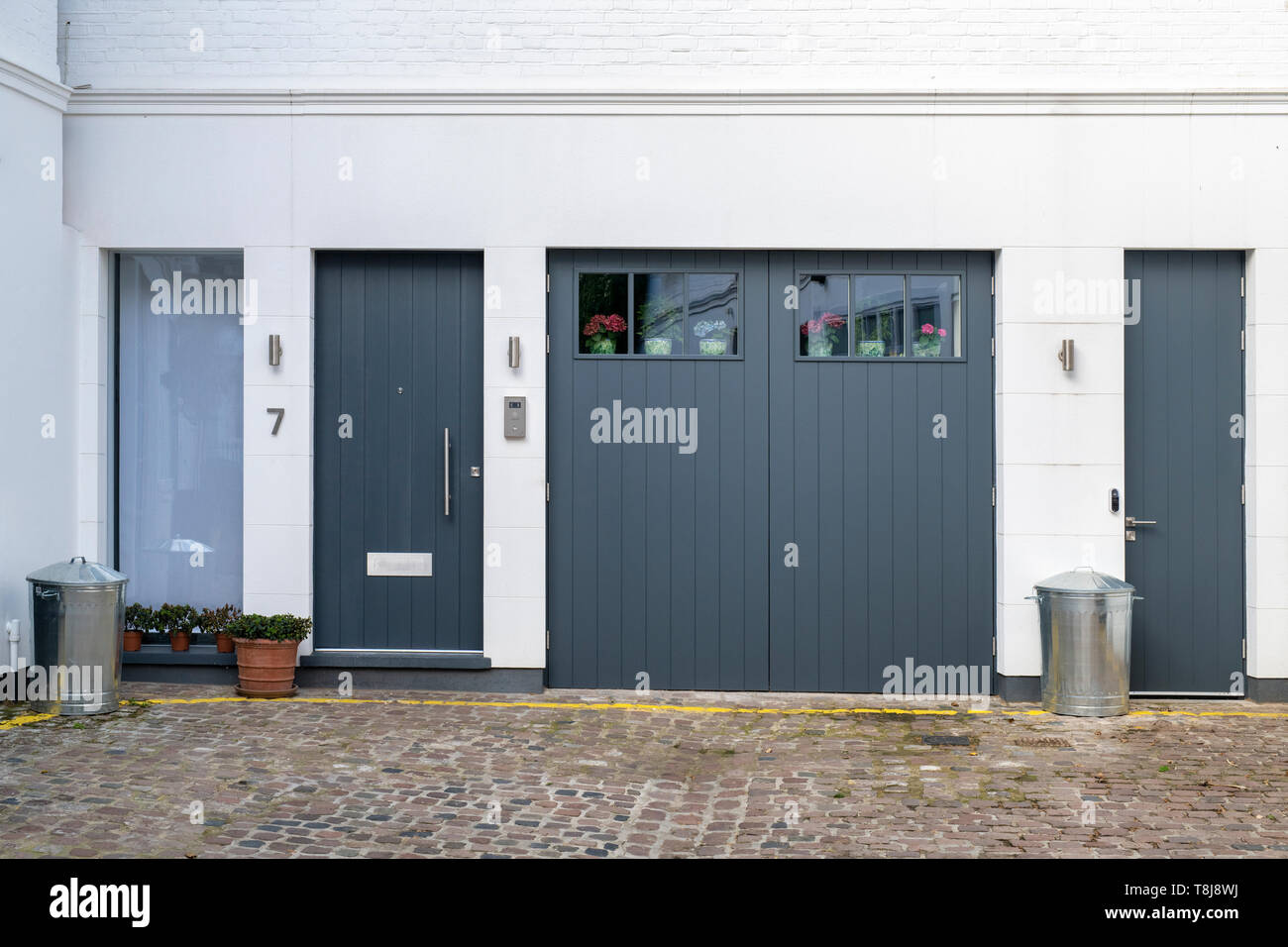 Grey painted garage and house doors in Laverton Mews, South Kensington, London, England Stock Photo
