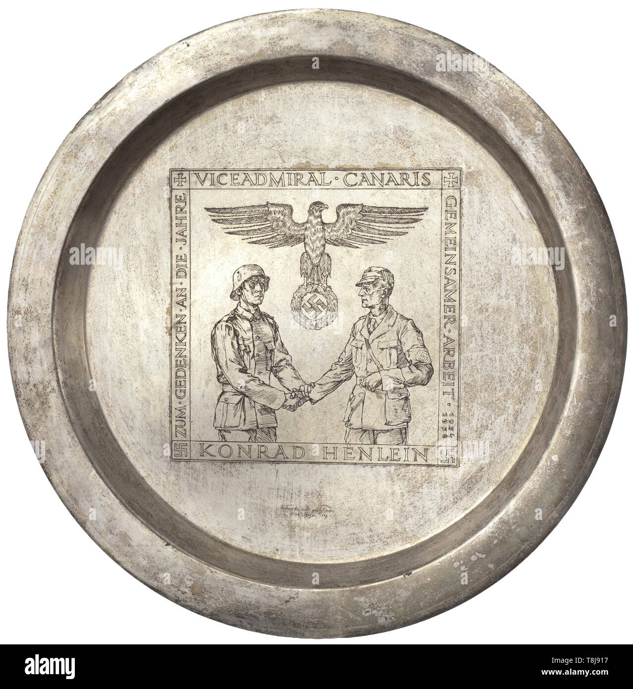 Konrad Henlein - a large presentation plate to the head of the foreign/defence department Wilhelm Canaris 1939 Hard silver-plated edition with elevated rim, the centre with etched depiction of a handshake between Wehrmacht and Party under the national eagle. Continuous dedication (tr.) 'Vice admiral Canaris - In commemoration of the years of cooperation 1934-1935 - Konrad Henlein', thereunder (tr.) 'Drafted and etched Max Geyer 1939'. On the reverse side a suspension hook. Diameter 51.5 cm. Max Geyer (1904 - 1958), Czechoslovakian painter and illustrator, studied at the Aca, Editorial-Use-Only Stock Photo