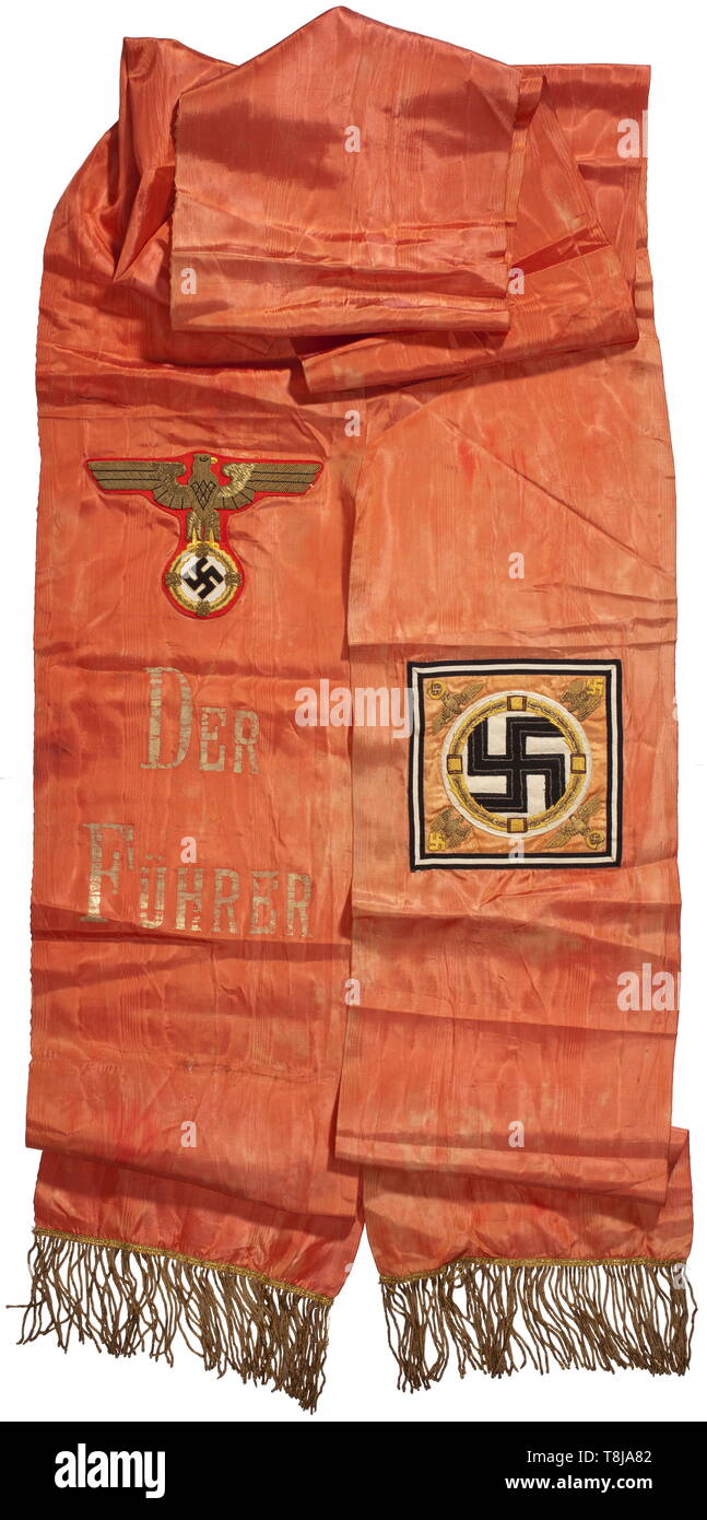 Adolf Hitler - a personal funeral sash as commander-in-chief of the Wehrmacht Red watered artificial silk edged with a gold fringe, one end bearing a national eagle appliquéd in gold embroidery on red cloth above an inscription in gold reading 'Der Führer', the other end with appliquéd 'Führerstandarte' in gold embroidery on ribbed silk. Somewhat faded. Total length circa 400 cm, width 27 cm. Extremely rare, completely preserved funeral sash, this size is virtually unheard of except at funerals to honour war heroes killed in action such as Werner Mölders. historic, historic, Editorial-Use-Only Stock Photo