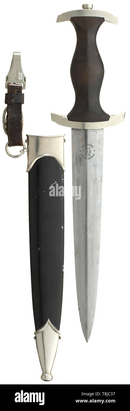 An SS service dagger M 33 by Robert Klaas, Solingen The blade with etched maker logo and motto. Nickel silver grip fittings, the cross guard punched 'I'. Black wooden grip with inset nickel silver eagle and enamelled SS emblem. Black lacquered steel scabbard (unusual for an early dagger) with nickel silver scabbard fittings. Short black leather hanger. All parts original. Length 38 cm. historic, historical, 20th century, 1930s, 1940s, Waffen-SS, armed division of the SS, armed service, armed services, NS, National Socialism, Nazism, Third Reich, German Reich, Germany, milit, Editorial-Use-Only Stock Photo