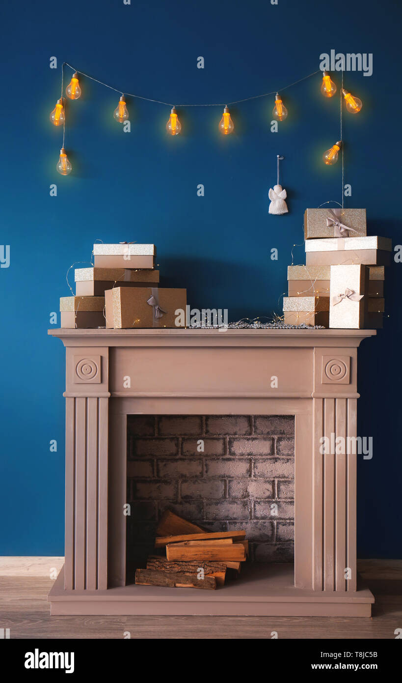 Glowing Christmas Garland Hanging On Wall Over Fireplace With Gift