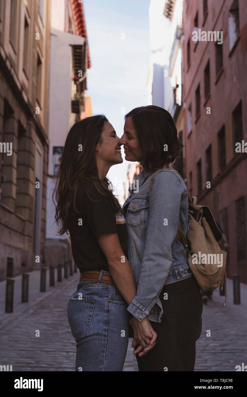 Attractive young women lesbian couple kissing and smiling in a street of  Madrid Stock Photo - Alamy