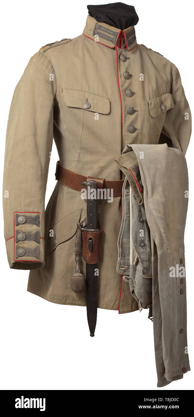 A uniform ensemble for an Oberleutnant of the Bavarian flying corps in the German mountain unit Light, unlined field tunic of reed-green cloth with red piping, patinated lion's head buttons, woven silver trim and sewn-on shoulder boards of the Infantry Lifeguards Regiment, unlined and with additional propeller appliqués, three pairs of orders loops. The breeches of stone-grey canvas, complete with white cotton lining and with remains of stampings. Brown double prong belt with frog, bayonet and officer's portepee. An obviously used, lightly faded ensemble of great rarity. hi, Editorial-Use-Only Stock Photo