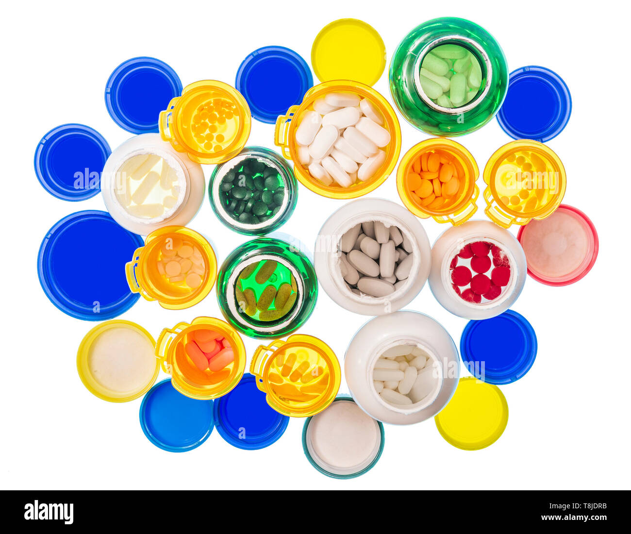 Horizontal shot looking down at a large group of various sizes and colors of pill bottles filled with pills.  Bottles and lids are on a light table. W Stock Photo