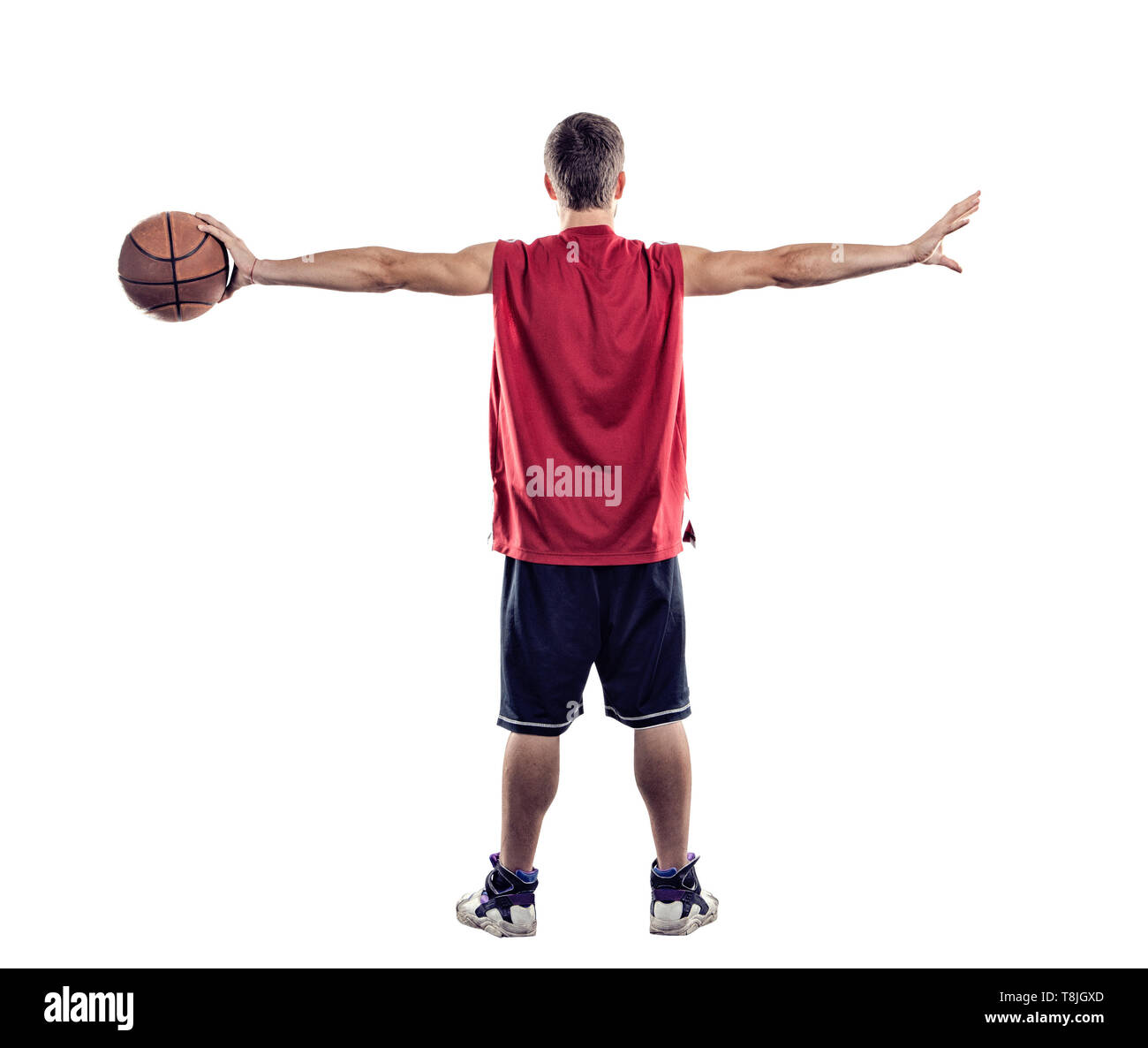 Basketball player standing back to camera with ball in hand isolated on white background Stock Photo