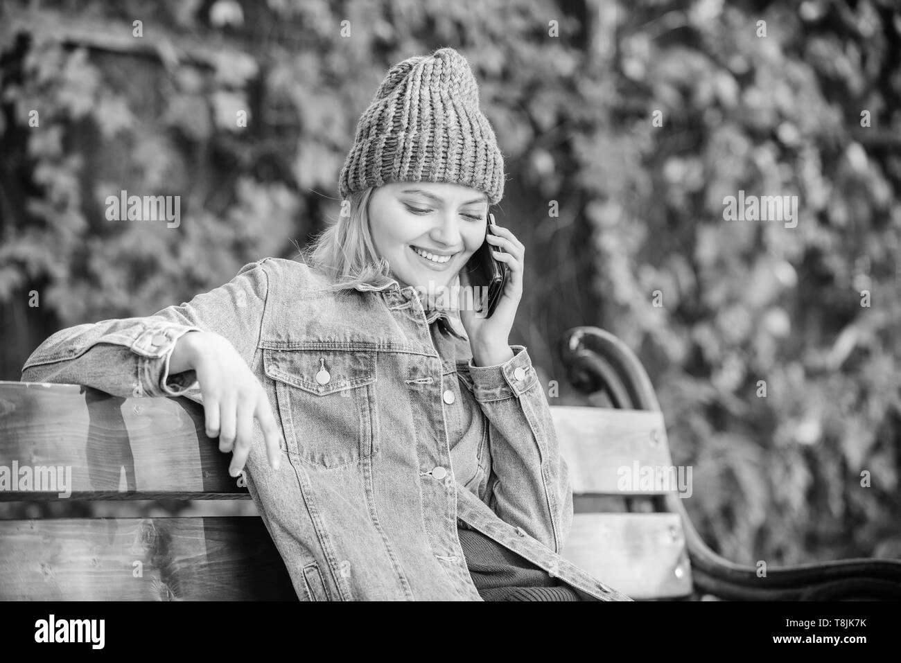 Girl busy with smartphone green nature background. Woman having mobile conversation. Girl smartphone call friend. Stay touch with modern smartphone. Mobile call concept. I am waiting for you in park. Stock Photo