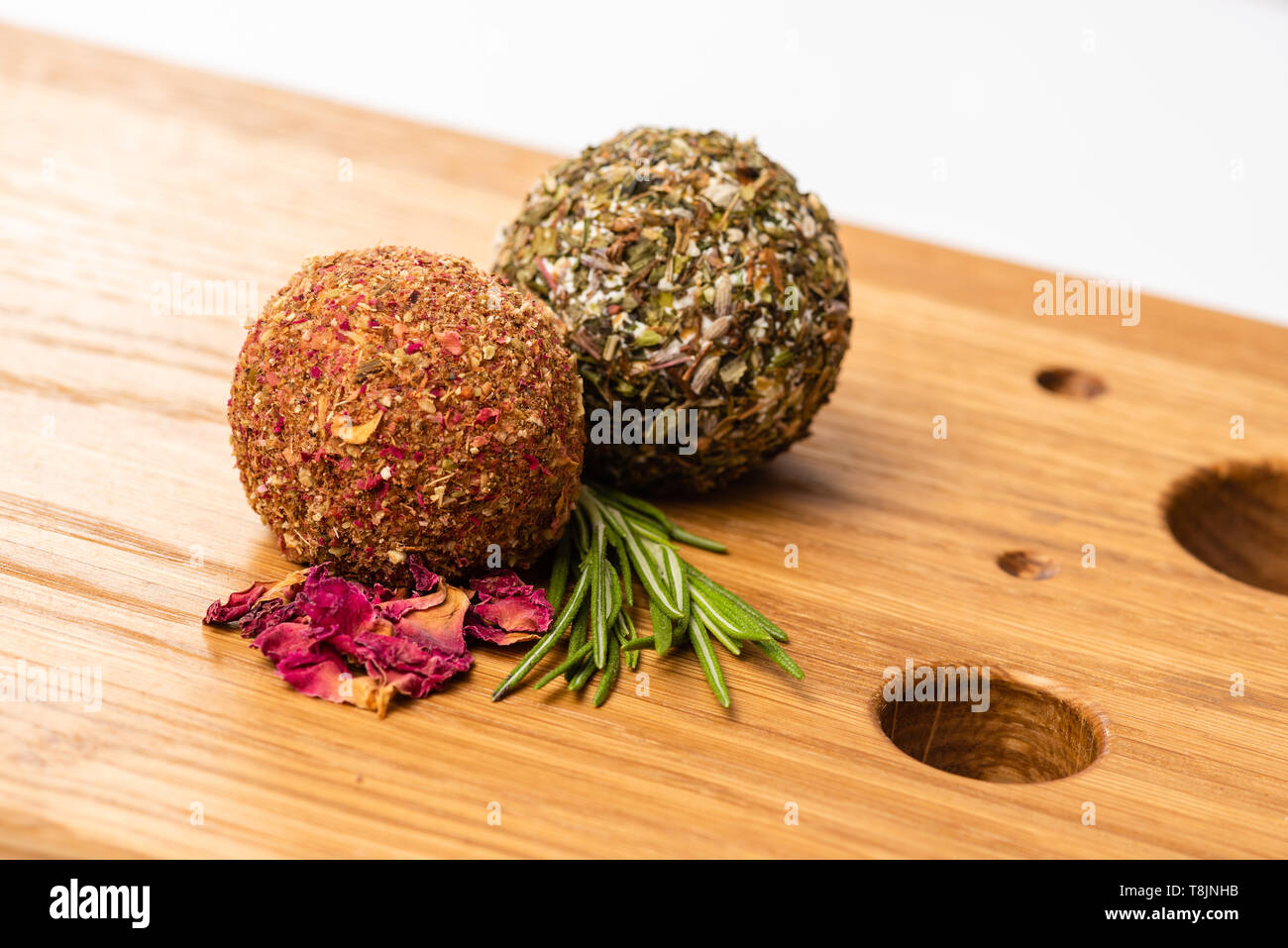 Close-up of two soft cheese balls labne with spices on wooden board. Stock Photo