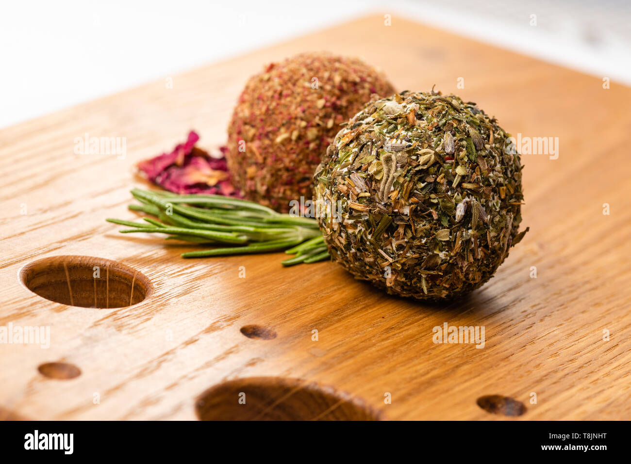 Close-up of two soft cheese balls labne with spices on wooden board. Stock Photo