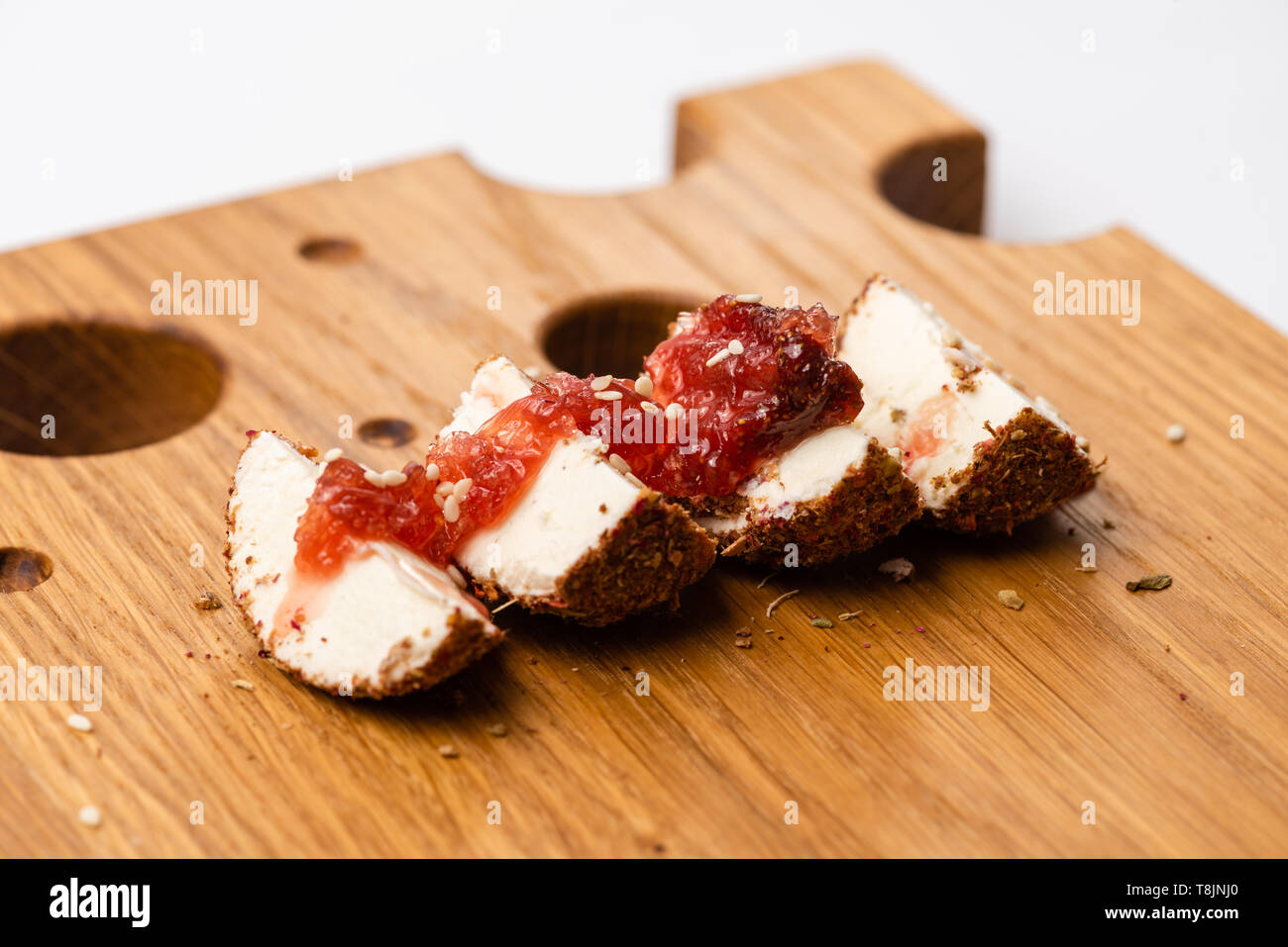 Close-up of soft cheese labne with jam on wooden board. Stock Photo