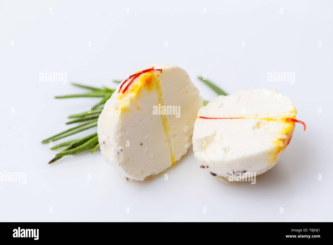 Two halves of cheese ball with sprig of thyme on white background. Stock Photo