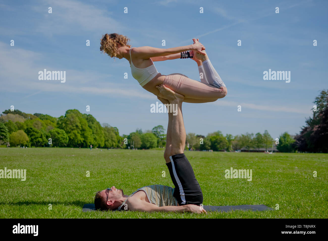 Two athletes performing duo acroyoga poses Stock Photo by Photology75