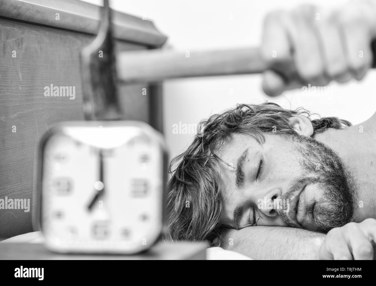 Annoying ringing alarm clock. Man bearded annoyed sleepy face lay