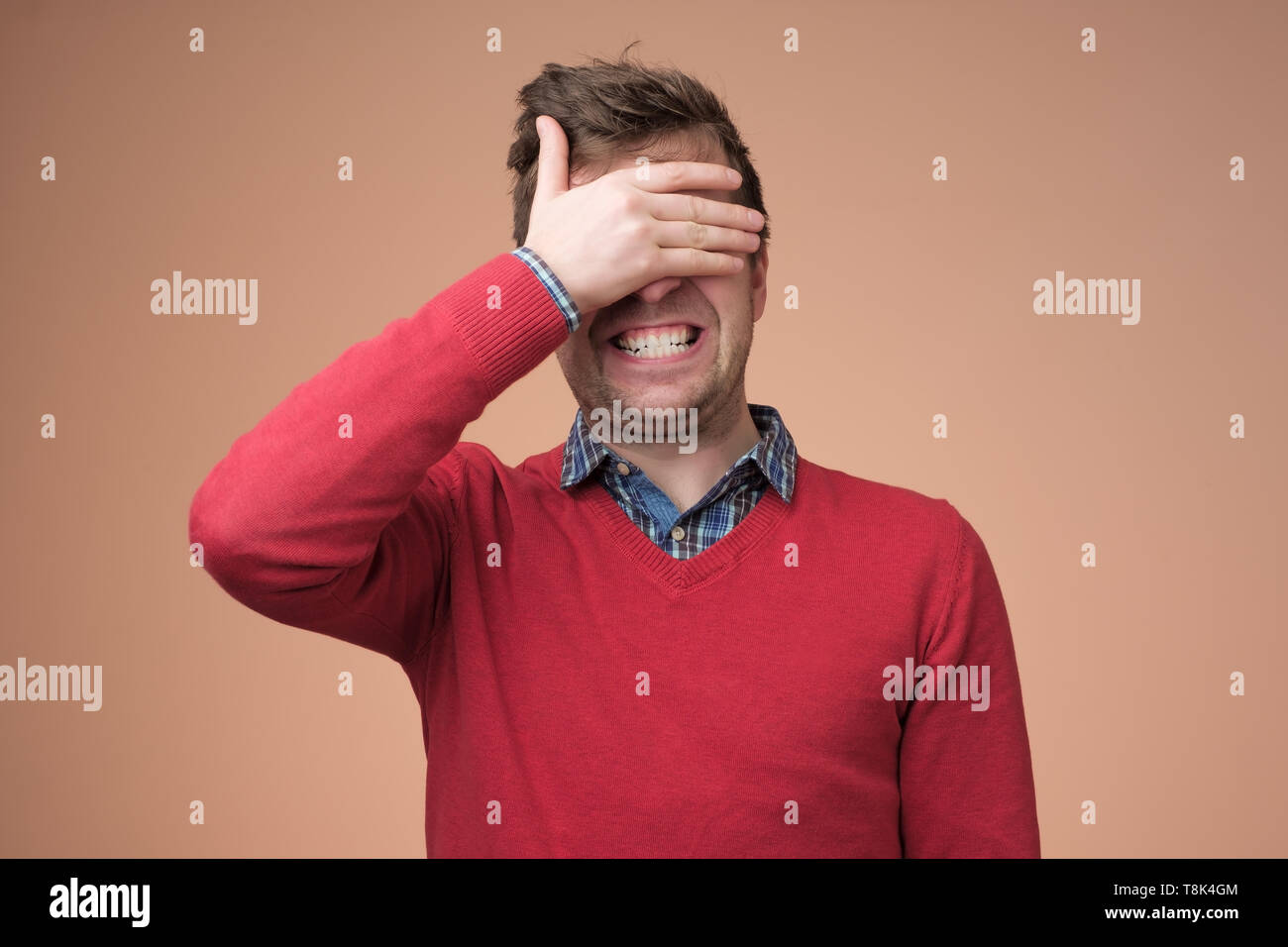 Young happy man covering eyes with hands Stock Photo Alamy