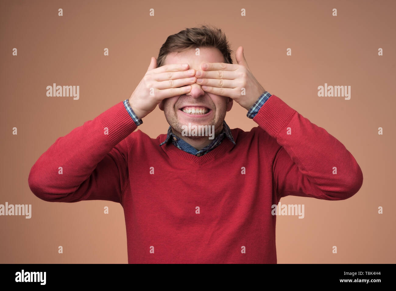 Young happy man covering eyes with hands Stock Photo Alamy