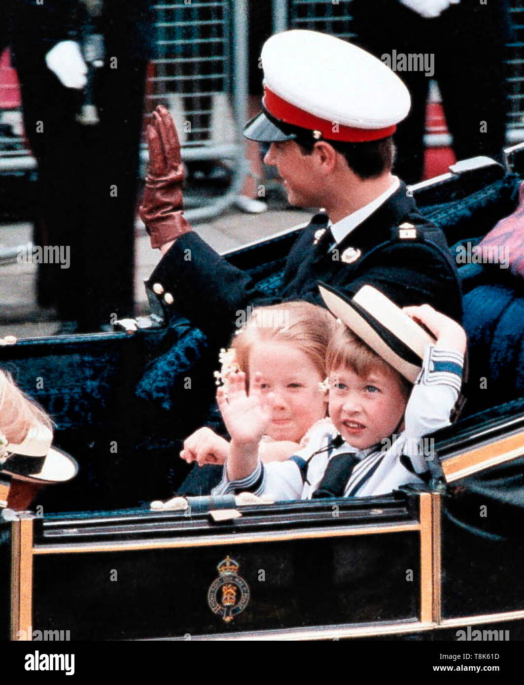AJAXNETPHOTO. 23RD JULY, 1986. LONDON, ENGLAND. - HELLO SAILOR! - PAGE BOY TO HRH PRINCE ANDREW AND SARAH FERGUSON AT THEIR WEDDING, 4 YEAR OLD HRH PRINCE WILLIAM DRESSED IN A SAILOR'S OUTFIT (NEAREST CAMERA, RIGHT.) STRUGGLES TO KEEP HIS HAT IN PLACE WHILE WAVING TO THE CROWD. WITH HIM IN THE CARRIAGE ARE BRIDESMAID LAURA FELLOWES AND HRH PRINCE EDWARD. PHOTO: JONATHAN EASTLAND/AJAX REF:862307 2 Stock Photo