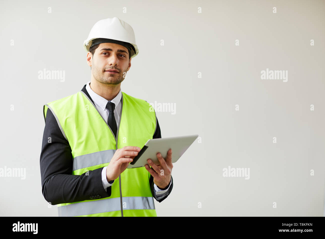 Pensive Engineer Holding Tablet Stock Photo