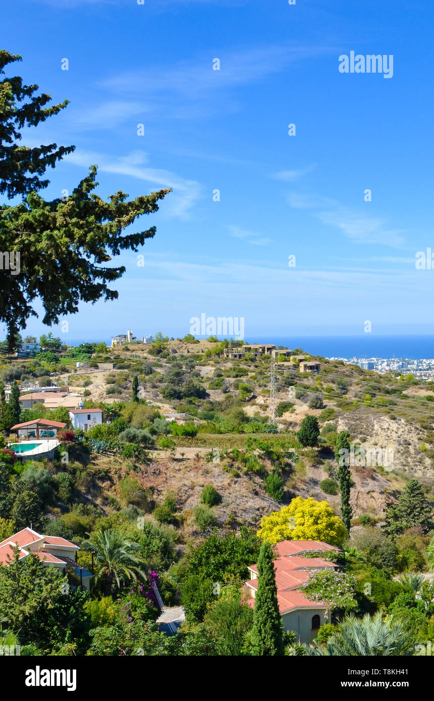 Vertical picture of amazing coastal landscape in Kyrenia region, Northern Cyprus. Rural houses surrounded by green trees are overlooking the sea Stock Photo
