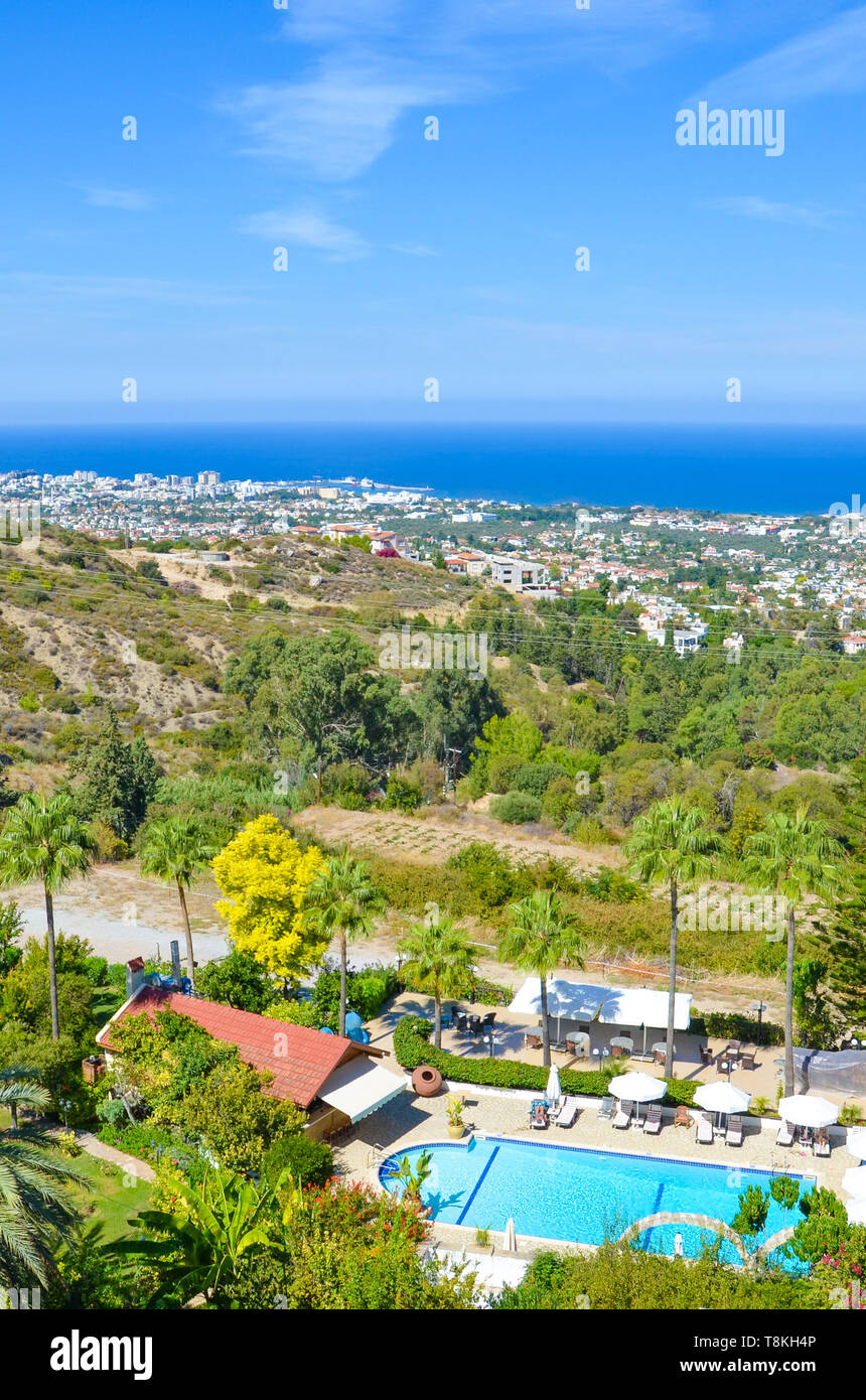 Stunning coastal landscape in Cypriot Kyrenia region taken in late summer. The rural houses and hotel complexes are overlooking the Mediterranean sea. Taken in city Bellapais. Stock Photo