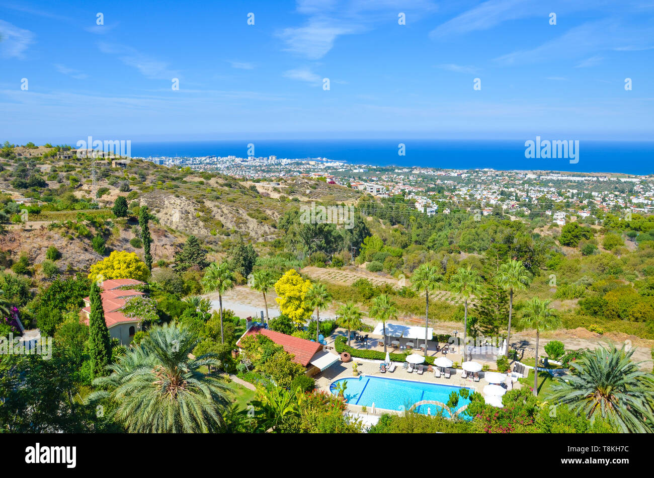 Paradise Mediterranean landscape in Kyrenia region, Northern Cyprus taken in late summer with rural buildings and hotel complexes with pools overlooking the sea. Amazing summer vacation destination. Stock Photo