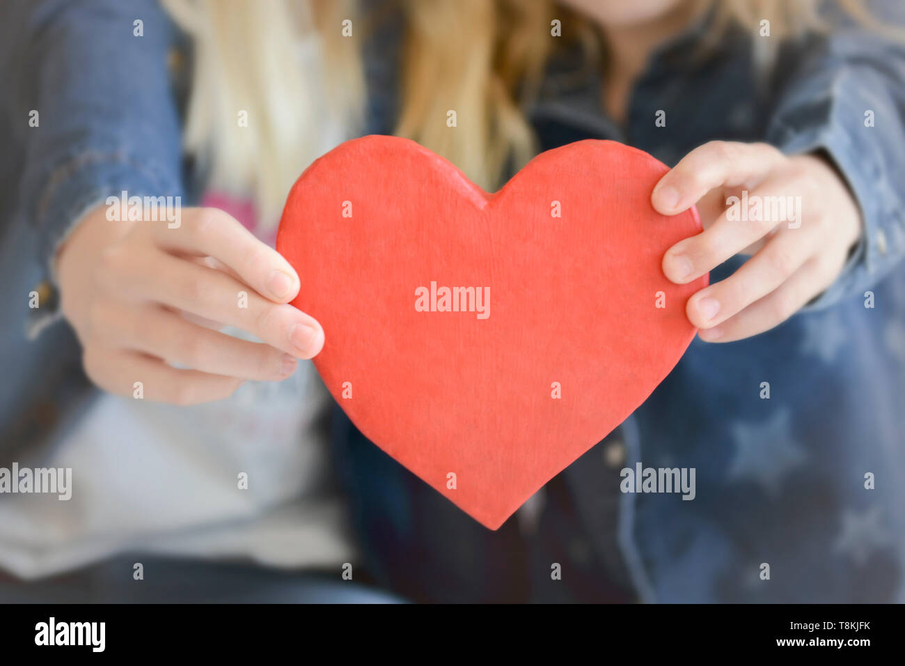Two pretty girls holding a heart at studio Stock Photo