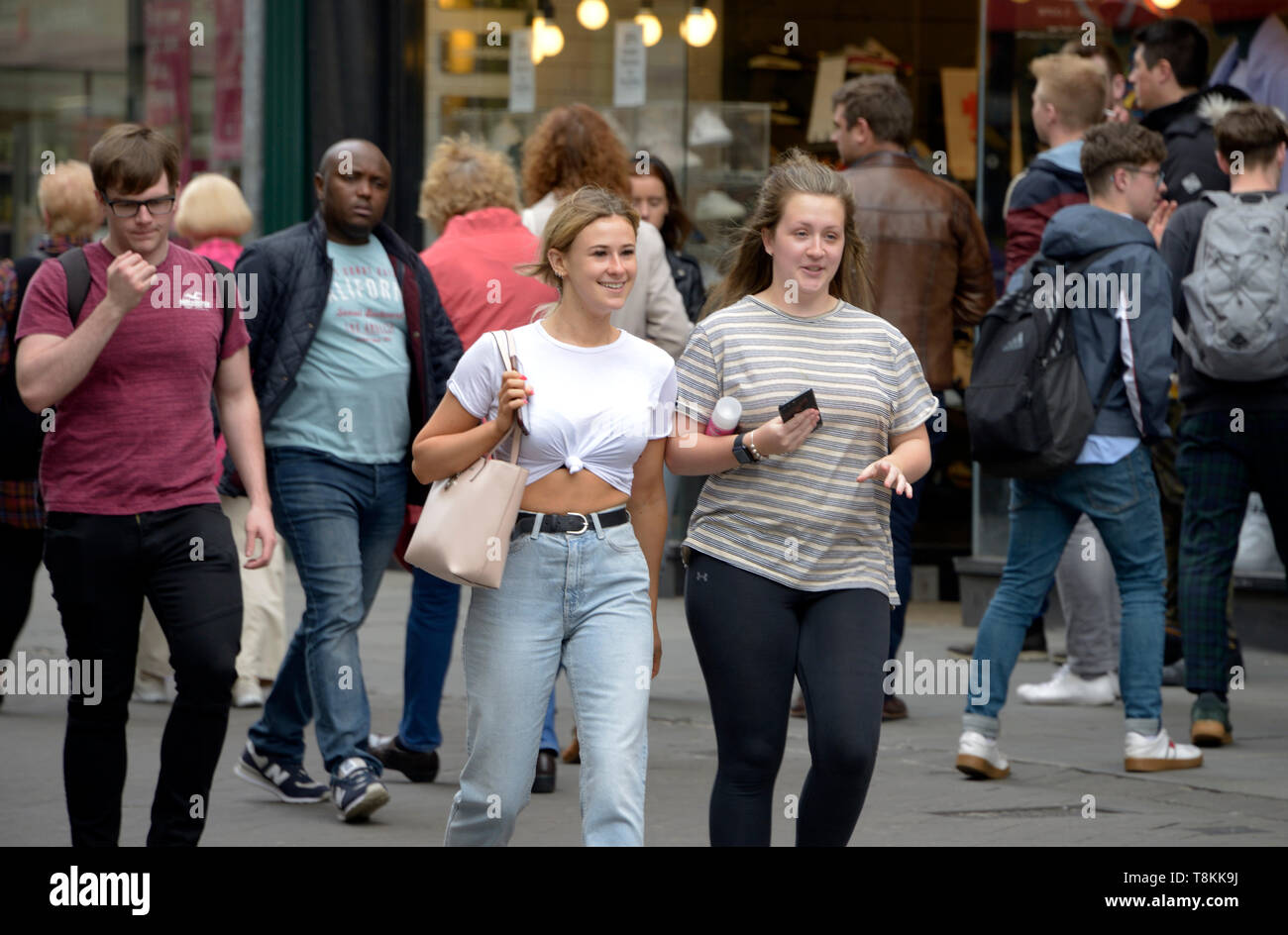 Girls walking in the street, chatting, out shopping. Stock Photo